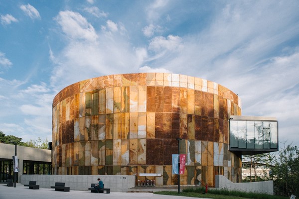 A newly constructed building in the form of an oil tank housing exhibition spaces