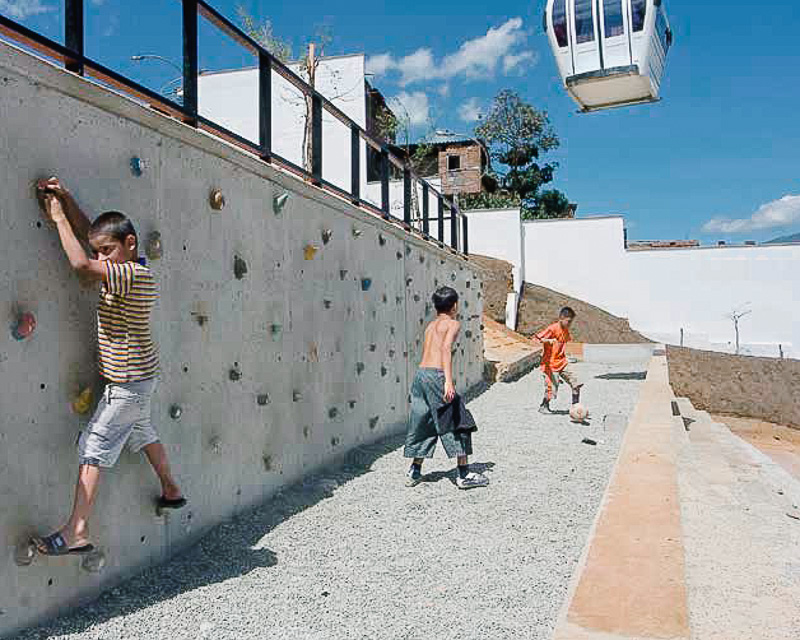 Children playing while the MetroCable soars overhead