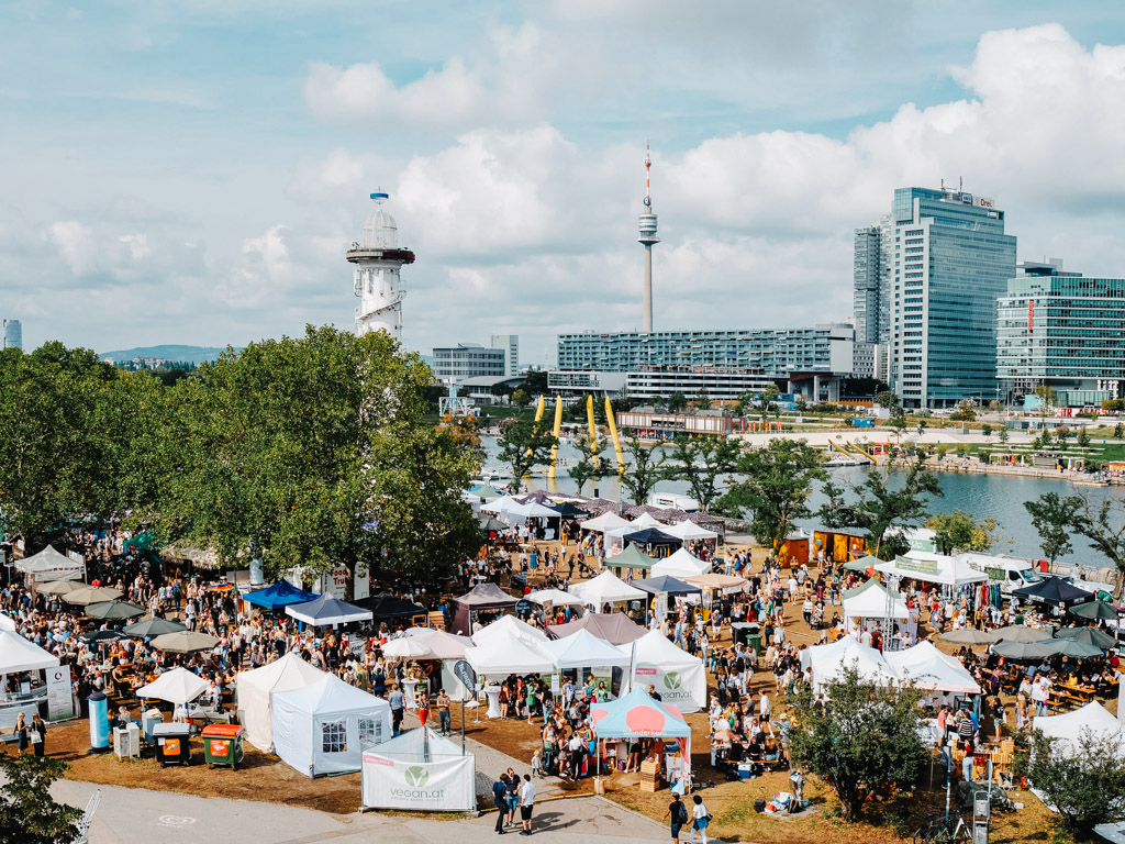 People enjoying a vegan festival at Leuchtturm Wiese on Danube Island